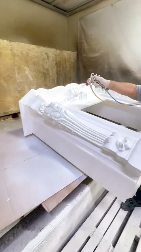 Usta şöminenin üst bölümünü uzaktan püskürtme tabancasıyla boyuyor