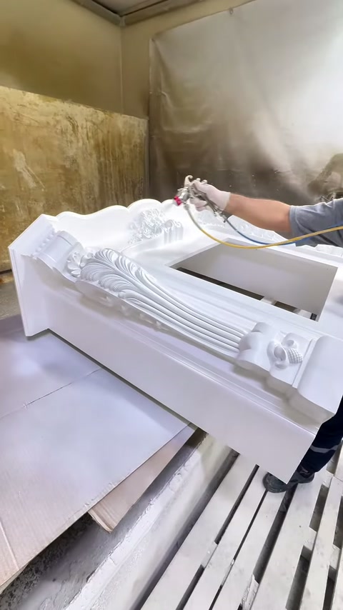 Kabartmalı şömine gövdesinin farklı yüzeylerine beyaz boya uygulanıyor