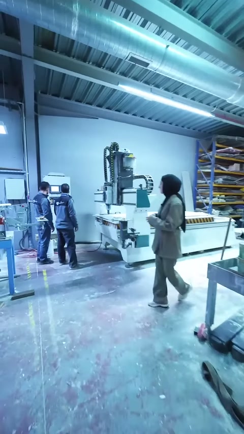 Üretim personeli CNC tezgâhının yanında işlem alanını kontrol ediyor