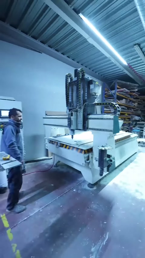 Çalışan CNC makinesinin yanında panel işleme alanını gözlemliyor