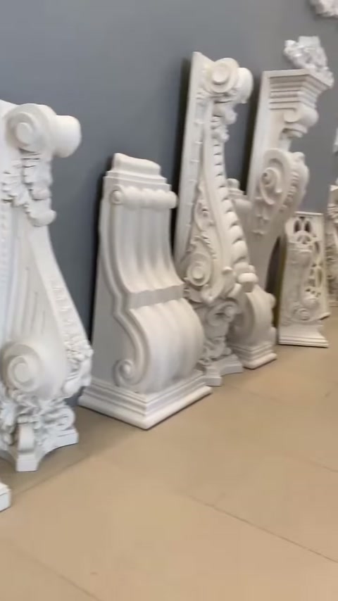 Showroom zemininde farklı boylarda oymalı dekoratif konsol parçaları sıralanıyor.