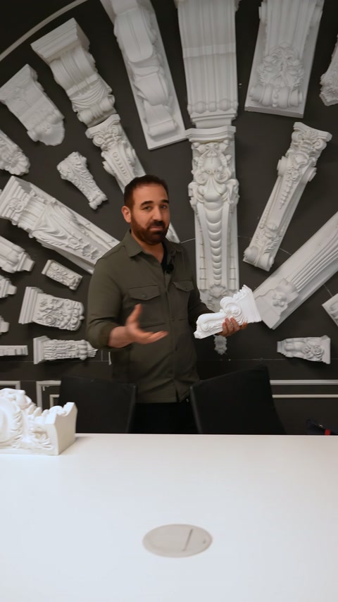 Duvar sergisindeki uzun payandalar önünde küçük modeller sunuluyor