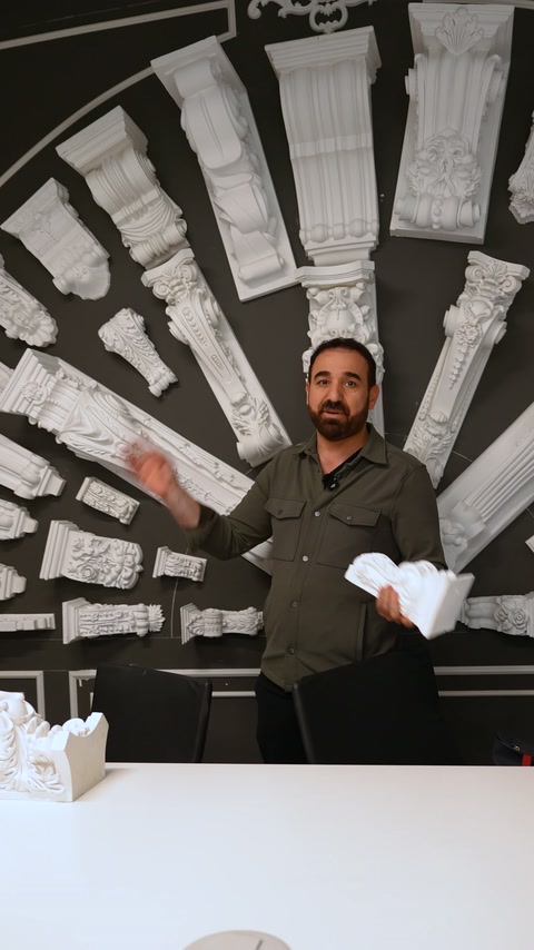 Sunucu, radyal düzende asılmış beyaz payandaları eliyle gösteriyor