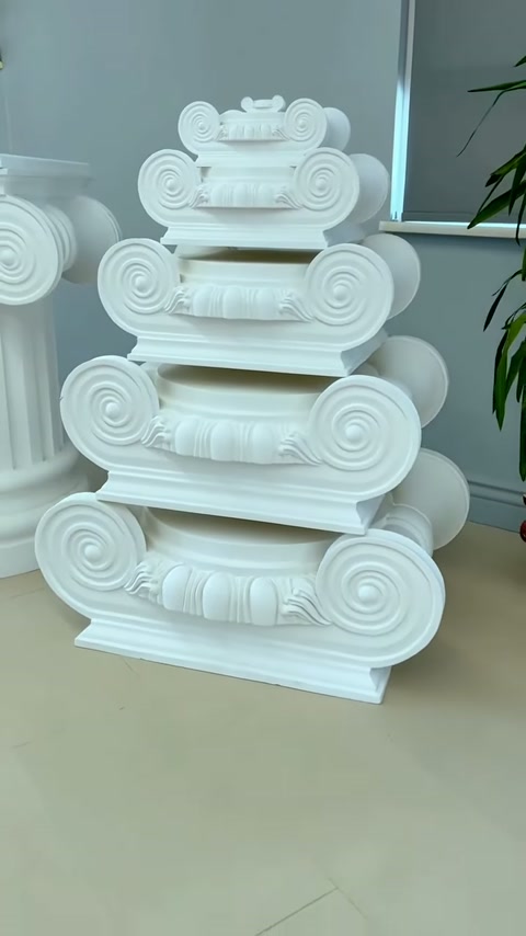 Beyaz dekoratif başlıkların katmanlı gövdeleri ve spiral uçları öne çıkıyor.