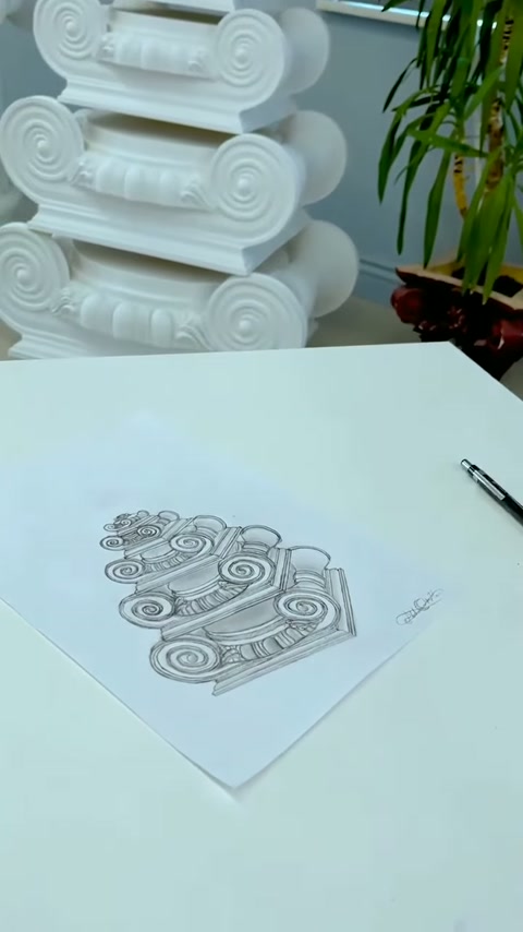 Bitmiş İyon sütun başlığı eskizi kalem yanında masada duruyor.