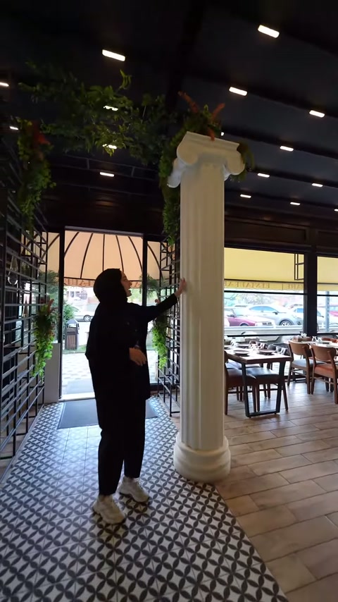 Beyaz İyon sütun, desenli zemin ile ahşap bölüm arasında görülüyor.
