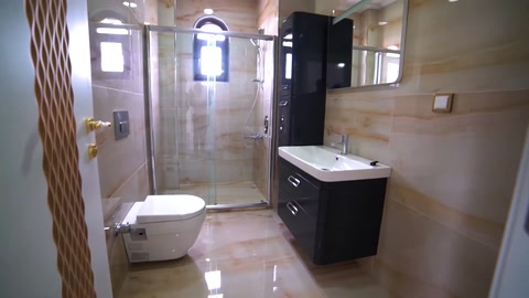 Banyoda lavabo dolabı, klozet ve mermer görünümlü yüzeyler