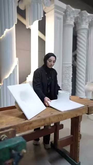 Sunucu masa başında kare aydınlatma numunelerinin yanında duruyor