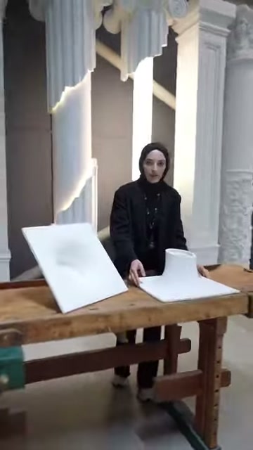 Amorf aydınlatma modelleri dekoratif sütunların önünde masada duruyor