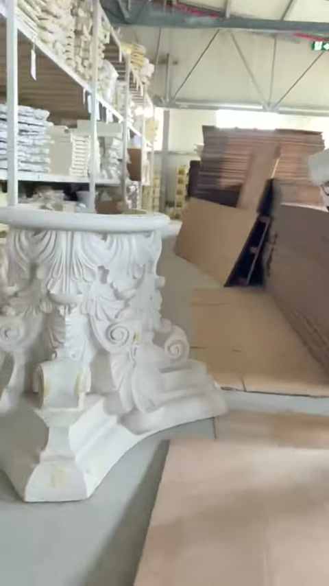 Kabartmalı sütun başlığı, depodaki levha yığınlarının önünde taranıyor.