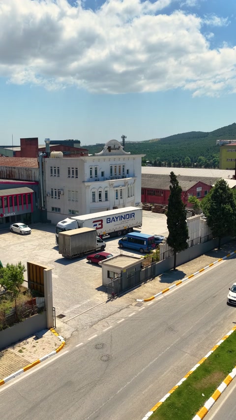 Havadan görünümde tesis girişinde kamyonlar ve otomobiller bulunuyor