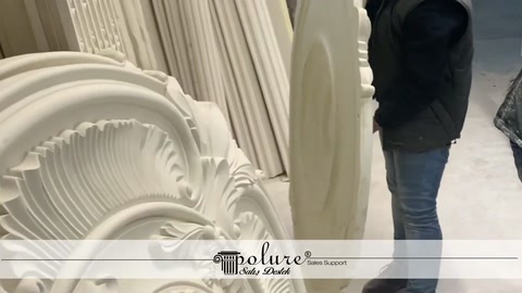 Çalışan duvara yaslanan büyük dekoratif göbeklerin önünde inceleme yapıyor