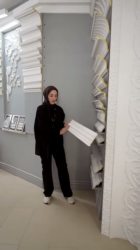Beyaz kartonpiyer parçası, sunucunun elinde kesiti görünecek biçimde duruyor.