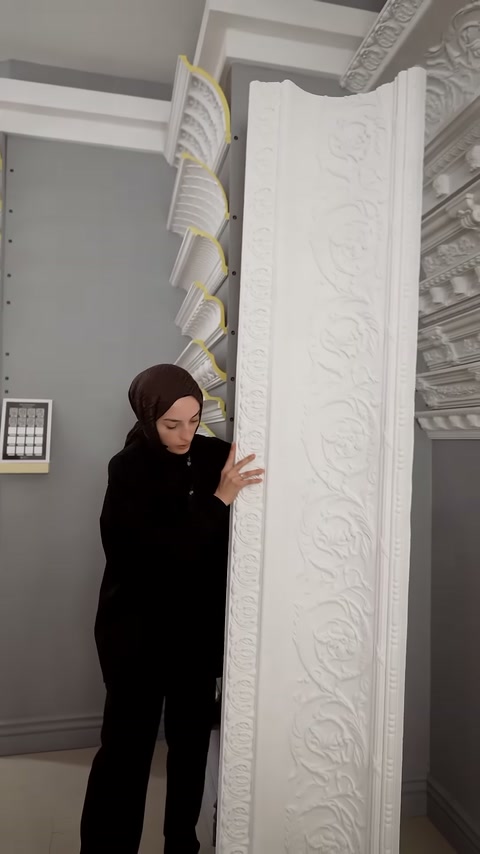 Sunucu, uzun dekoratif panelin alt bölümündeki işlemeleri inceliyor.