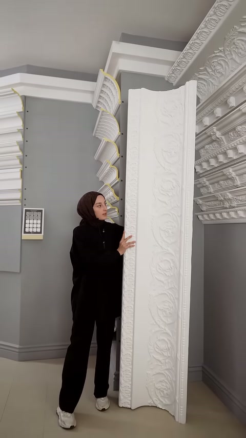 Sunucu, motifli panel ile kartonpiyer rafları arasında duruyor.