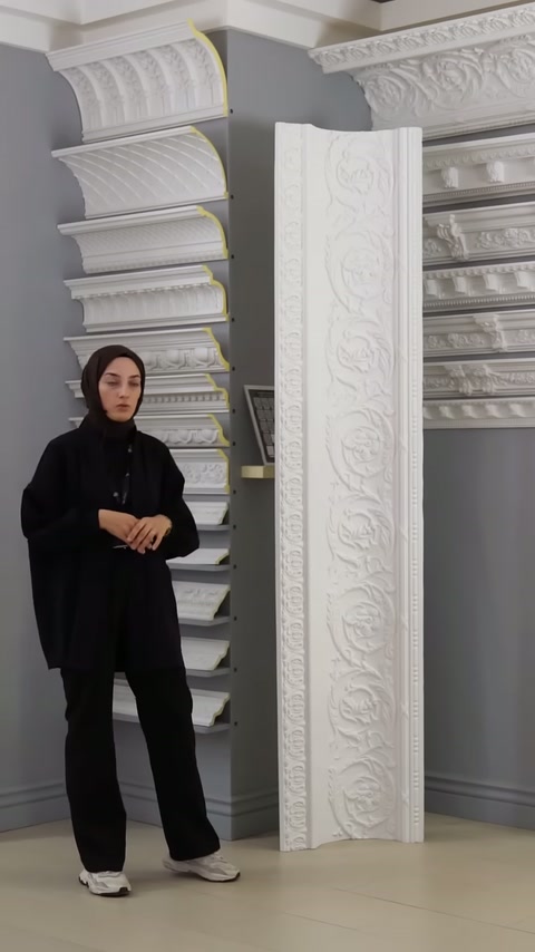 Sunucu, kabartmalı uzun panellerin yanında kartonpiyer koleksiyonunu anlatıyor.