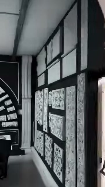 Yüksek pencereli showroom duvarında çerçeveli süsleme örnekleri bulunuyor