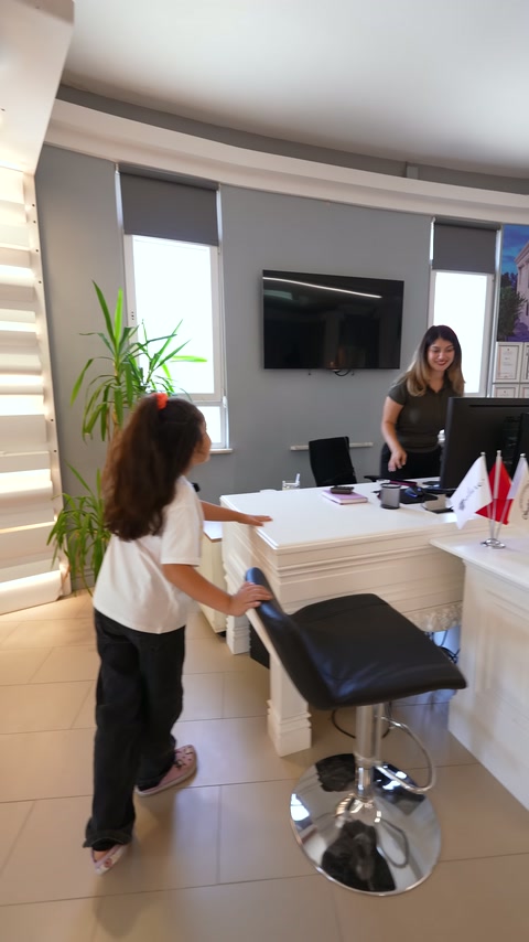 Ofis bölümünde beyaz süslemeli masa ve siyah koltuk görülüyor.