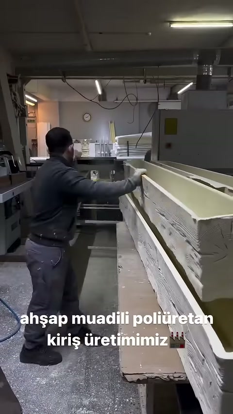 İşçi mertek profilini üretim makinesinin girişine doğru çekiyor.
