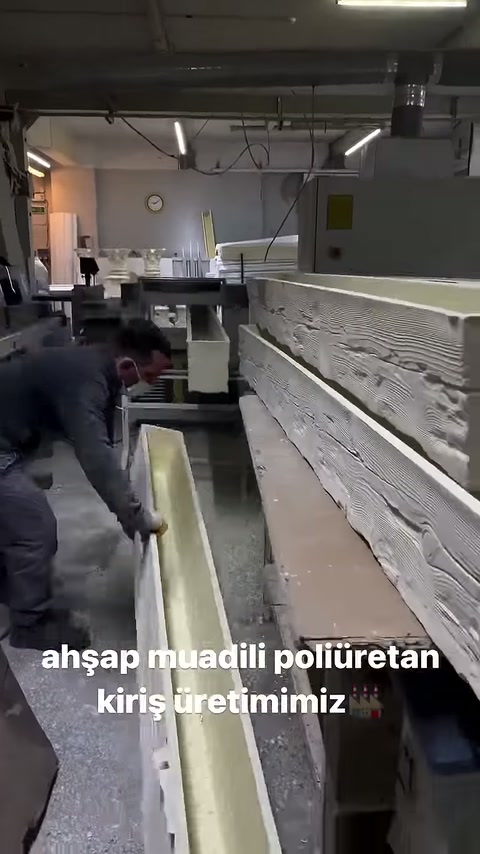 Kabartılı ahşap desenli kiriş makine yanında yatay sergileniyor.