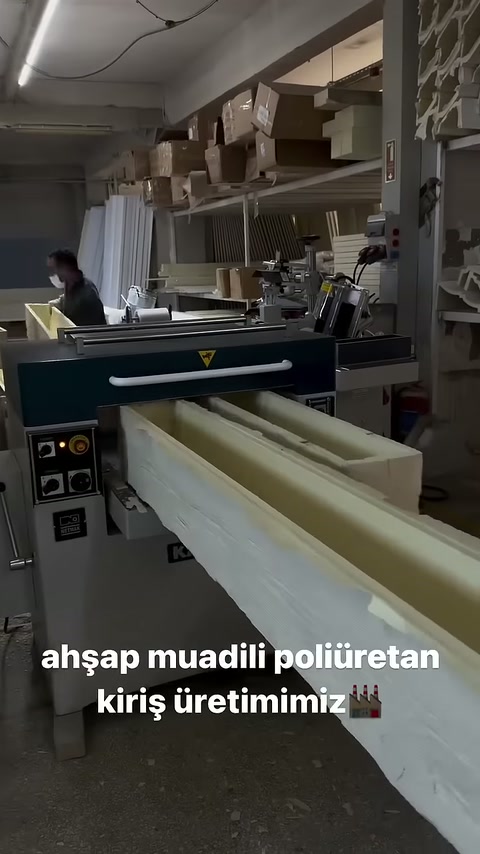 İşlenen uzun profil atölyedeki makineden dışarı doğru uzanıyor.