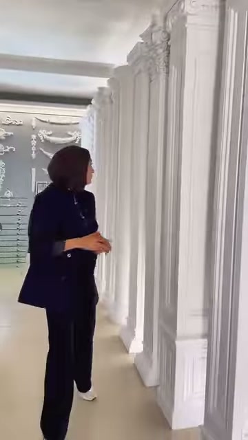 Farklı başlık ve gövdelere sahip beyaz sütunlar koridor boyunca diziliyor.