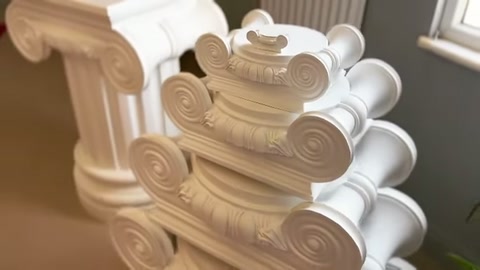 Üst üste dizili sütun başlıklarının kıvrımlı yan detayları görülüyor.