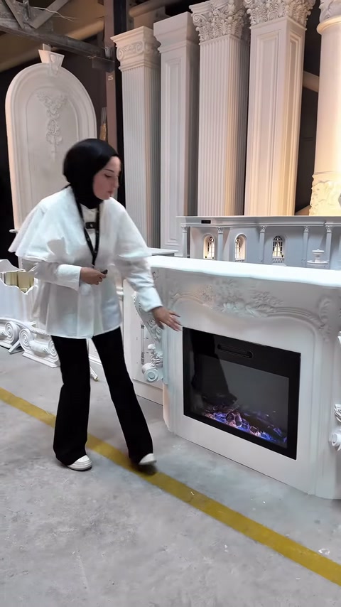 Sunucu elektrikli hazneye yönelerek şöminenin kullanım bölümünü gösteriyor