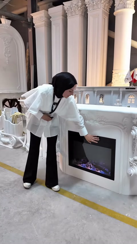 Sunucu şömine haznesinin ön yüzünü eliyle işaret ediyor