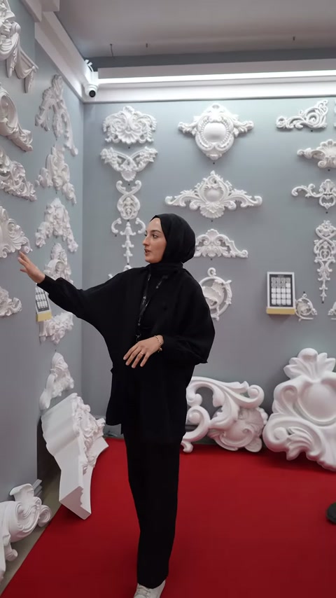 Sunucu duvardaki çiçekli ve kıvrımlı dekor örneklerini işaret ediyor