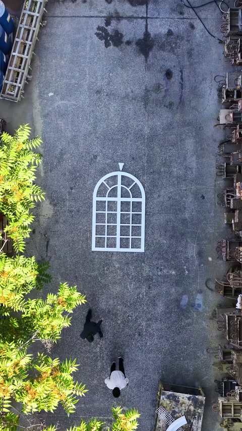 Beyaz kemerli pencere iskeleti açık atölye zemininde tek başına duruyor