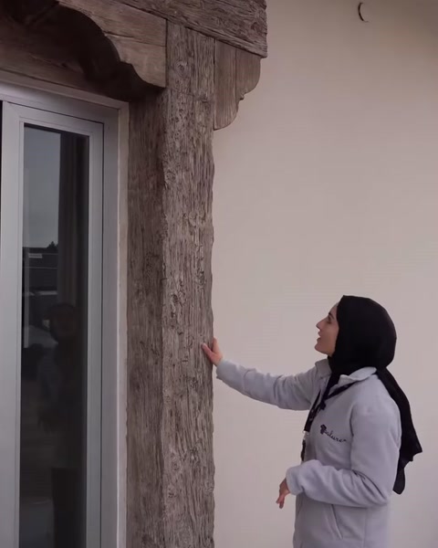 Dış cephede pencere yanında uygulanan ahşap görünümlü dikey kiriş