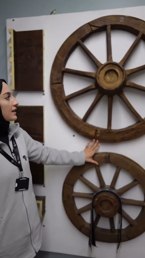Sunucu, büyük dekoratif at arabası tekerinin çemberini gösteriyor