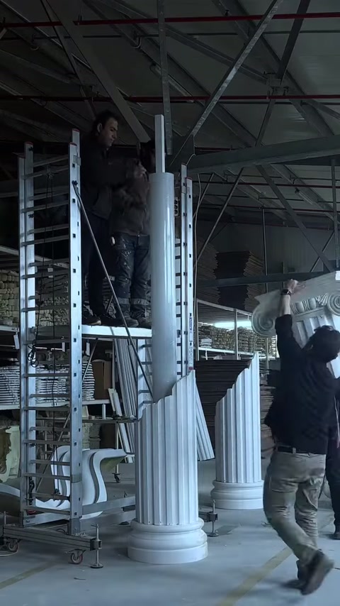 Ustalar İyon başlığını yivli sütun gövdesinin üzerine kaldırıyor.